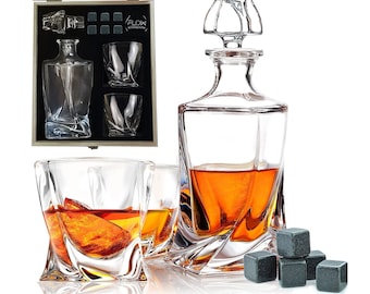 Puede incluir: Un juego de vasos de whisky y una decanter con tapón, todo en una caja de madera. La decanter y los vasos son de vidrio transparente con un diseño de espiral. La caja es negra con la palabra "FLOKI" impresa en ella. El juego también incluye piedras de whisky negras.