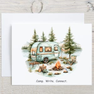 May include: Watercolor illustration of a camping scene with a teal camper, campfire, and trees. The image includes a small table, a wooden chair, and the text "Camp. Write. Connect."