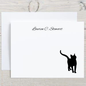 May include: White stationery set featuring a black cat silhouette and the name "Lauren C. Stewart" in elegant script. The set includes a folded card and an envelope, perfect for personalized notes.