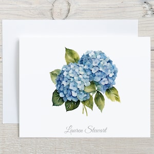 May include: A watercolor illustration of a bouquet of blue hydrangeas with green leaves. The name "Lauren Stewart" is written in cursive at the bottom of the image.