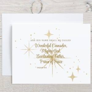 May include: A white greeting card featuring gold glitter-style star illustrations and the text: AND HIS NAME SHALL BE CALLED Wonderful Counselor, Mighty God, Everlasting Father, Prince of Peace, ISAIAH 9:6. The card is paired with a matching envelope.
