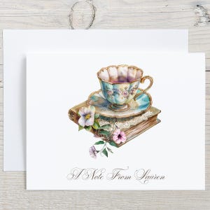 May include: Watercolor illustration of a teacup and saucer atop two antique books with floral accents. The teacup is light blue with gold trim and floral designs. The text "A Note From Lauren" is at the bottom.