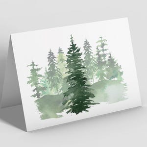 Puede incluir: Una tarjeta de felicitaci&oacute;n plegada con una pintura de acuarela de una escena de bosque. La obra de arte representa varios &aacute;rboles de hoja perenne en tonos verdes, con un fondo suave y borroso. La tarjeta es blanca.