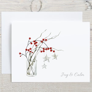 May include: A white greeting card featuring a watercolor illustration of bare branches with bright red berries in a clear glass vase. Three light gray star ornaments hang from the branches. The text Joy & Calm is printed in gray.