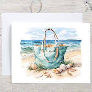 May include: Watercolor illustration of a beach scene with a teal tote bag labeled "Elizabeth" on a sandy shore. Seashells and starfish are scattered around the bag, with the ocean and sky in the background. The bag has tan handles.