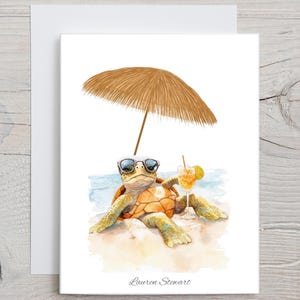 May include: Watercolor illustration of a sea turtle wearing sunglasses, relaxing under a straw umbrella on a beach. A cocktail with a lemon slice sits nearby. The artwork is signed "Lauren Stewart".