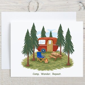 May include: Greeting card featuring a camping scene with a red camper, blue folding chair, picnic table, and campfire. Tall green trees surround the campsite, with a blue sky and clouds in the background. The text "Camp. Wander. Repeat." is at the bottom.