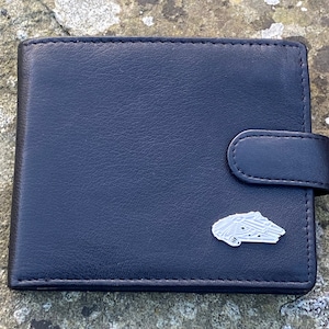 May include: A black leather wallet with a silver pin of the Millennium Falcon spaceship from Star Wars.