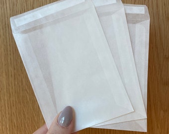 Puede incluir: Tres sobres de papel blanco con una tira autoadhesiva en la solapa.