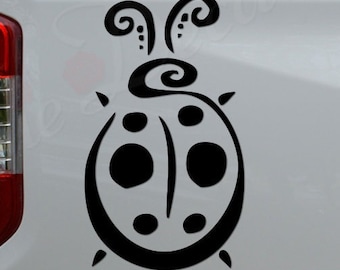 May include: Black and white ladybug decal with a swirl design on a white truck tailgate. The decal is placed on the right side of the tailgate. The text "Rosie Decals" is visible on the truck's bumper.