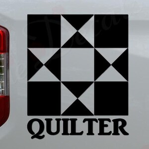 May include: Black and white quilt block design with the word "Quilter" below it. The design is on the back of a white pickup truck.