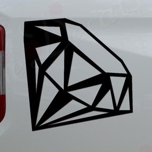 May include: A black geometric diamond decal on a white truck bed. The decal is in the shape of a diamond with a geometric pattern. The truck bed is white and has a black bumper. The decal is placed on the side of the truck bed.