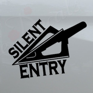 May include: A white truck with a black decal that says "Silent Entry" with a graphic of a tool. The decal is on the back of the truck.