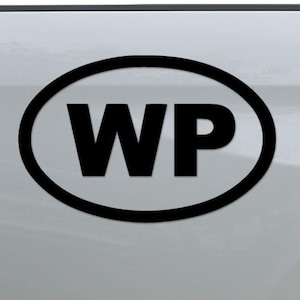 May include: A black oval sticker with the letters "WP" in bold, white font. The sticker is affixed to the white body of a vehicle, near the taillight. The vehicle's bumper is visible.
