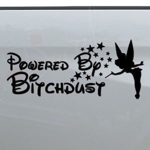 May include: A white pickup truck with a black vinyl decal on the back. The decal features a silhouette of Tinkerbell with a wand and stars, and the text "Powered By Bitchdust".
