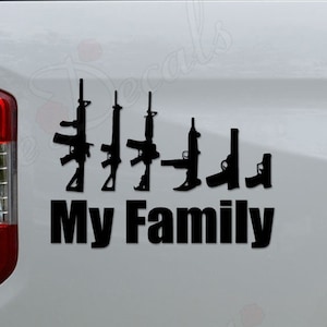 May include: Black and white silhouette of five rifles with the text "My Family" on a white truck tailgate.