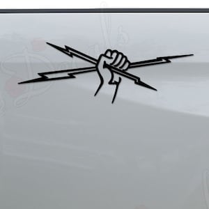 May include: A white pickup truck with a black vinyl decal of a fist holding two lightning bolts on the back passenger side.