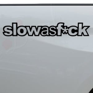 May include: A white pickup truck with a black decal that says "slowasf*ck" on the back. The truck also has a black decal that says "Rosie Decals" on the bumper.