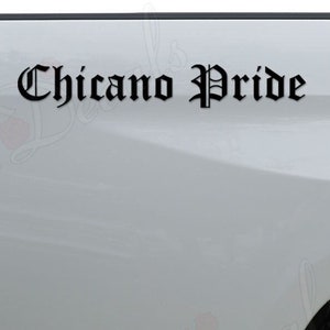 May include: A white pickup truck with a black vinyl decal that reads "Chicano Pride" in a gothic font.