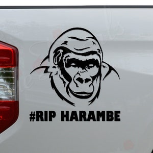 May include: A white pickup truck with a black gorilla silhouette and the text "#RIP HARAMBE" on the back.