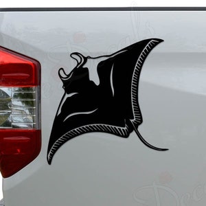 May include: Black silhouette of a manta ray decal on the back of a white pickup truck.