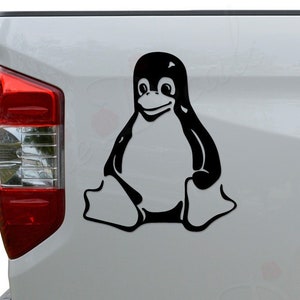 May include: Black and white penguin sticker on the back of a white pickup truck.