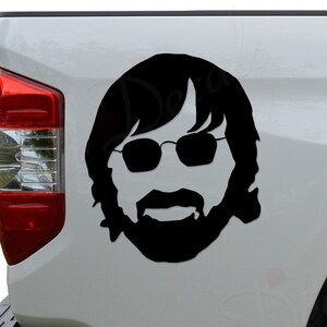 May include: Black and white silhouette of a man with a beard and sunglasses on a white truck tailgate.