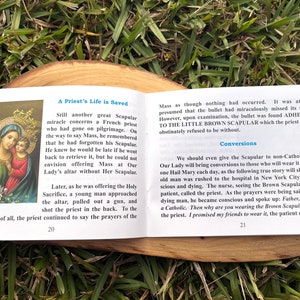 May include: A book with a brown cover and a picture of the Virgin Mary and baby Jesus on the front. The book is titled "A Priest's Life is Saved" and has text about the importance of the brown scapular.