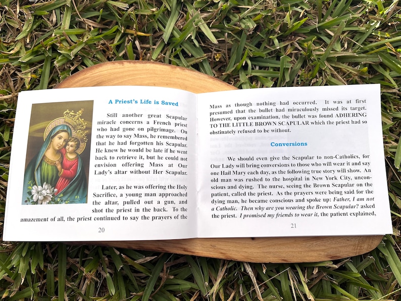 May include: A book with a brown cover and a picture of the Virgin Mary and baby Jesus on the front. The book is titled "A Priest's Life is Saved" and has text about the importance of the brown scapular.