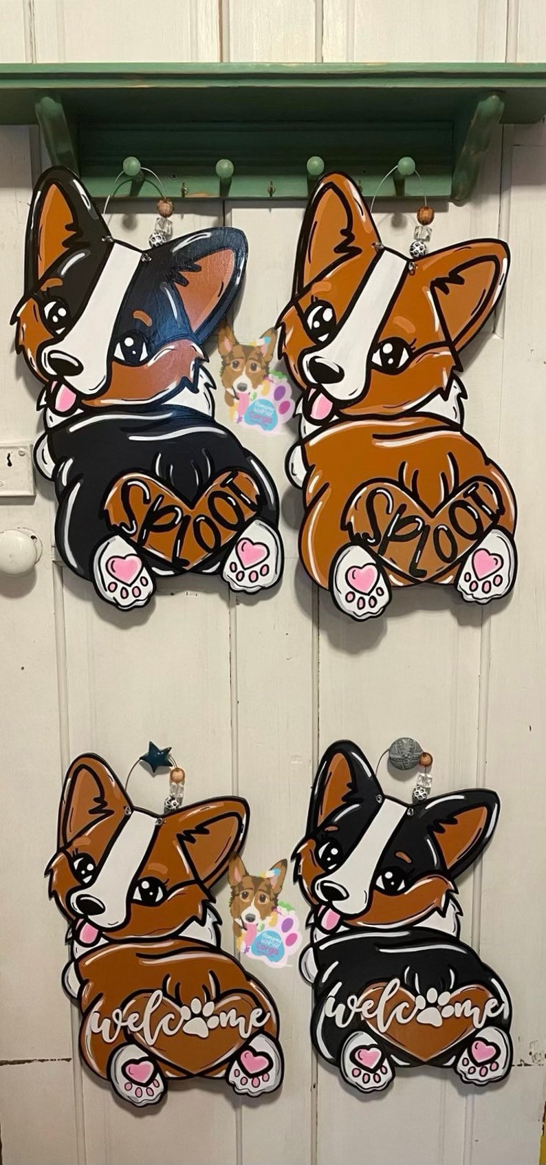 Puede incluir: Cuatro recortes de madera de corgis en diferentes poses. Dos son marrones y blancos con la palabra "SPLOOT" en la espalda. Uno es negro y blanco con la palabra "welcome" en la espalda. El &uacute;ltimo es marr&oacute;n y blanco con la palabra "welcome" en la espalda.