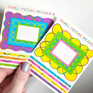 May include: Two small picture frames with colorful designs. One frame has a blue background with a green and white frame, and the other has a green background with a pink and white frame. The text "SMALL PICTURE FRAMES" is printed at the top.