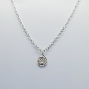 May include: A silver chain necklace with a small, silver spiral pendant.