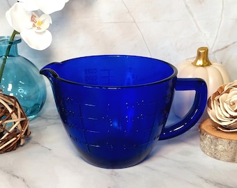 Peut inclure: Un pichet doseur en verre bleu cobalt avec une anse. Le pichet est gradué en tasses, en onces et en millilitres.