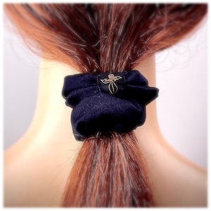 May include: A dark blue fabric hair scrunchie with a gold embroidered logo that says "Tantilla"