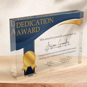 May include: A blue and gold glass plaque with the text "Dedication Award" and a gold ribbon. The plaque is presented to Jason Gooder for his incredible achievement. The date is 25.07.24.