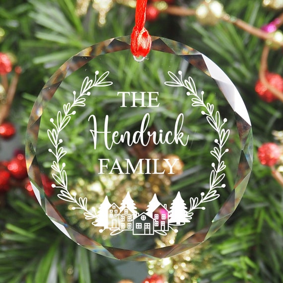 A laser-engraved crystal bauble with a custom family name in a full Christmas village scene — genuinely pretty, personal, and the kind of ornament that becomes a yearly tradition.