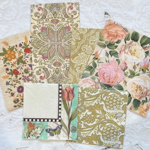 May include: Five decorative paper napkins with floral and paisley patterns. The napkins feature a variety of colors, including pink, green, brown, and white.