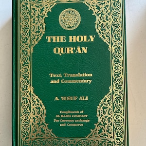 以下が含まれることがあります： A. Yusuf Ali著『The Holy Qur'an, Text, Translation and Commentary』というタイトルの緑色のハードカバー本。表紙には金色の文字と複雑な金色の縁取りデザインが施されており、Compliments of Al Rajhi Companyというテキストが記載されています。