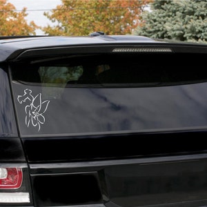 May include: A white outline of a flower with leaves is on the back window of a black SUV.