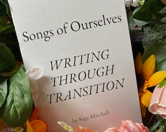 May include: A book titled "Songs of Ourselves: Writing Through Transition" by Sage Mitchell, surrounded by pink, yellow, and green flowers.