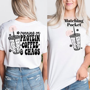 May include: White t-shirt with black text that reads "running on protein coffee & chaos" and a black and white illustration of a cup of iced coffee. The shirt has a matching pocket with the same illustration.