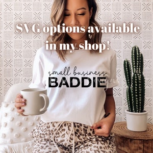 K&ouml;nnte beinhalten: Eine Frau tr&auml;gt ein wei&szlig;es T-Shirt mit dem Aufdruck "small business BADDIE". Die Frau h&auml;lt eine wei&szlig;e Tasse und sitzt auf einem Stuhl mit einer Kakteenpflanze im Hintergrund. Der Text "SVG options available in my shop!" ist &uuml;ber das Bild gelegt.