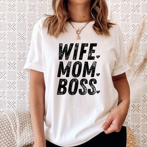 May include: White t-shirt with black text that reads "Wife Mom Boss" with a small heart after each word.