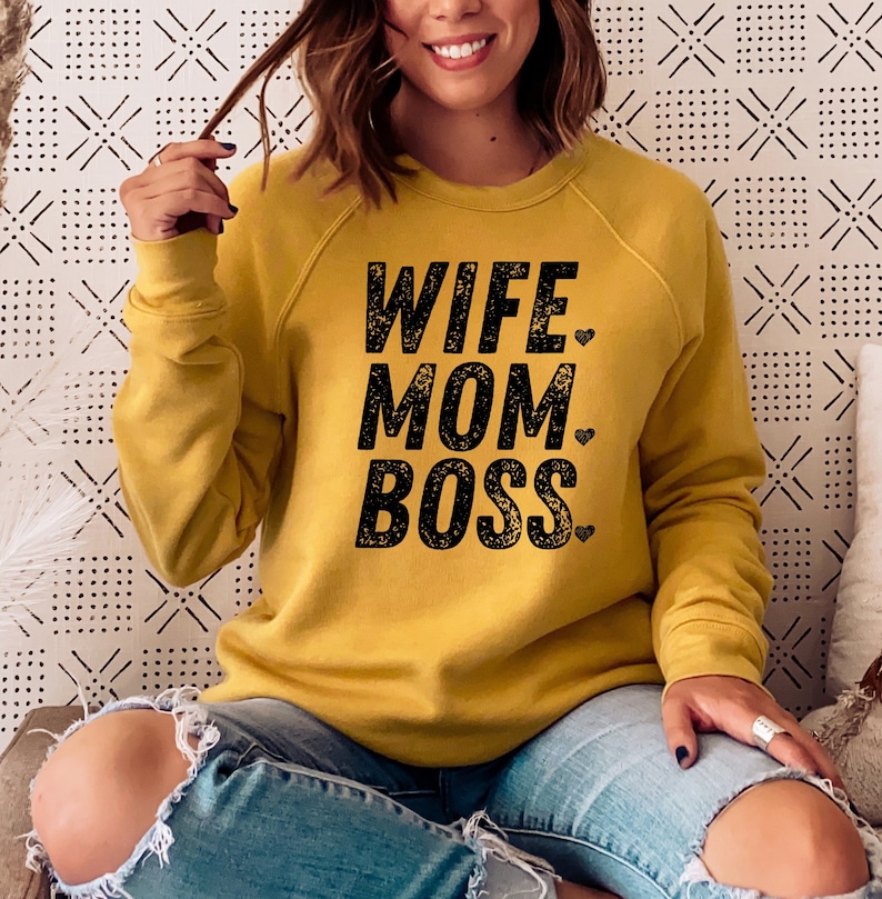 May include: A mustard yellow sweatshirt with the text "Wife Mom Boss" in black with a small heart after each word.