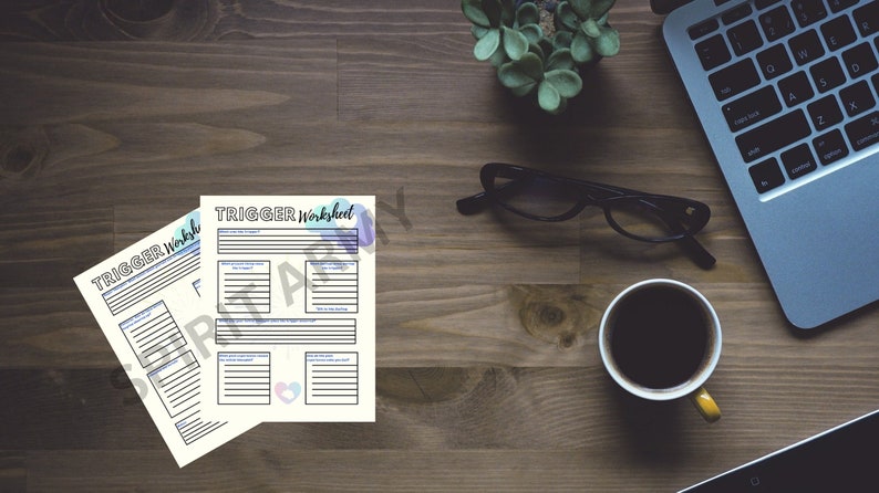 Pu&ograve; includere: Due fogli di lavoro stampabili con il titolo "TRIGGER Worksheet" su un tavolo di legno con un laptop, una tazza di caff&egrave; e un paio di occhiali.