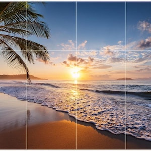 May include: A scenic beach scene at sunrise. The image features a sandy beach with gentle waves, a palm tree, and a vibrant sky with clouds. The sun is rising over the ocean, casting a golden glow.