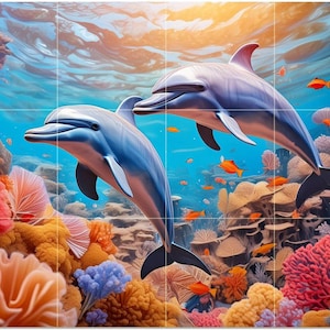 May include: A vibrant underwater scene featuring two dolphins swimming near colorful coral reefs and small orange fish. The dolphins are shades of blue and gray, with black fins, set against a bright blue ocean background.