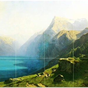 May include: A painting of a mountain lake scene with a blue lake in the foreground and a mountain range in the background. The mountains are covered in green trees and snow. The sky is a light blue.