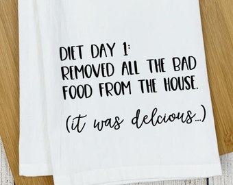 May include: White kitchen towel with black text that reads "Diet Day 1: Removed all the bad food from the house. (It was delicious...)"