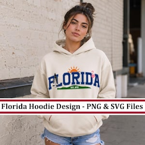 Puede incluir: Sudadera con capucha color crema con la palabra "FLORIDA" en letras azules, un gráfico de sol y un flamenco rosa. La sudadera también presenta una franja verde con el texto "EST. 1945". El texto "Florida Hoodie Design - PNG & SVG Files" se muestra en una pancarta blanca.